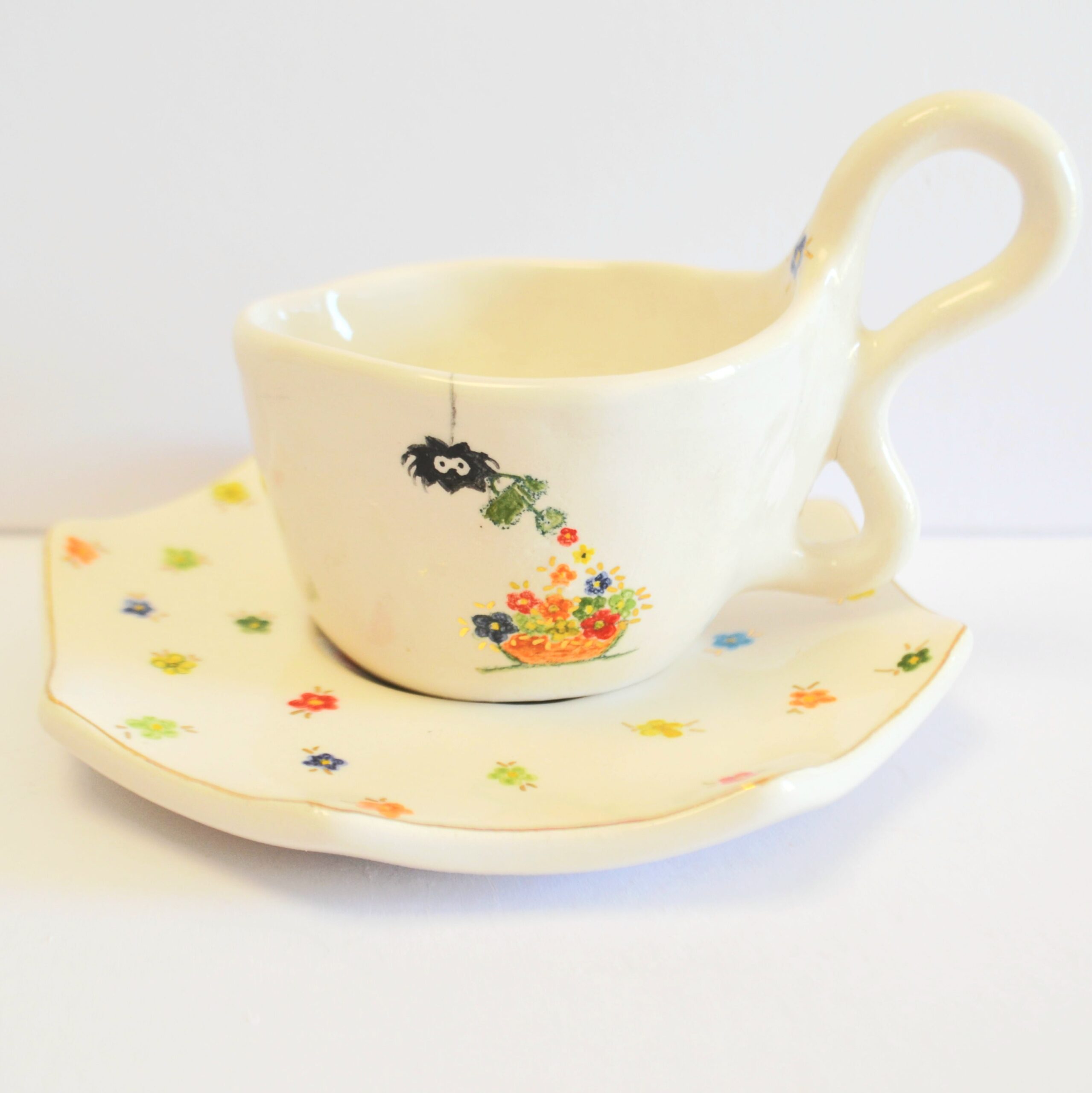 Handcrafted white stoneware cup with a unique organic handle, featuring a hand-painted spider watering tiny colorful flowers.